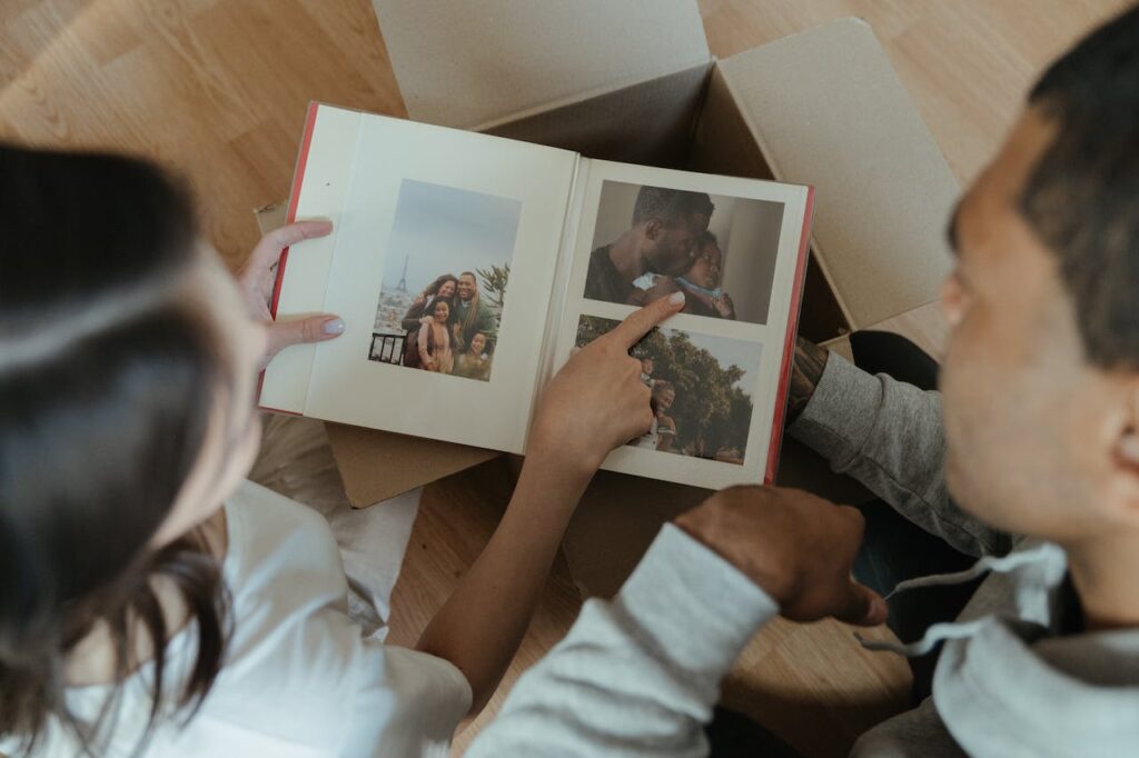 Two people looking through a picture album while packing