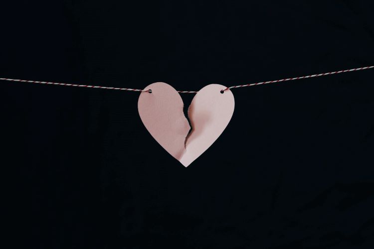 A broken pink heart on a string.